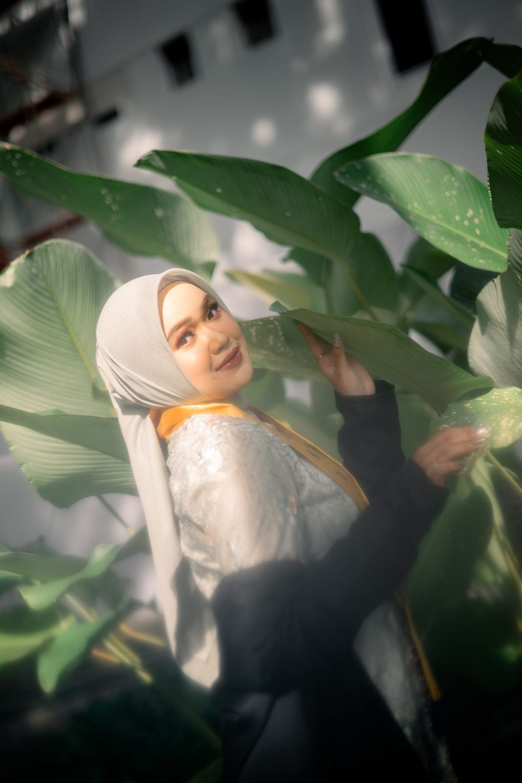 Graduate standing in soft natural light.